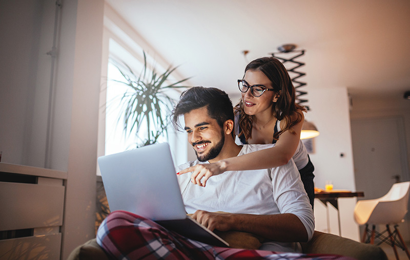 A couple looking at a laptop together at home
